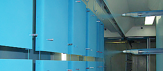 Produkte werden mit blauem Pulver in Serie automatisiert beschichtet