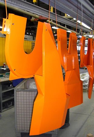 Orange Maschinenteile in der Aufhängung frisch beschichtet